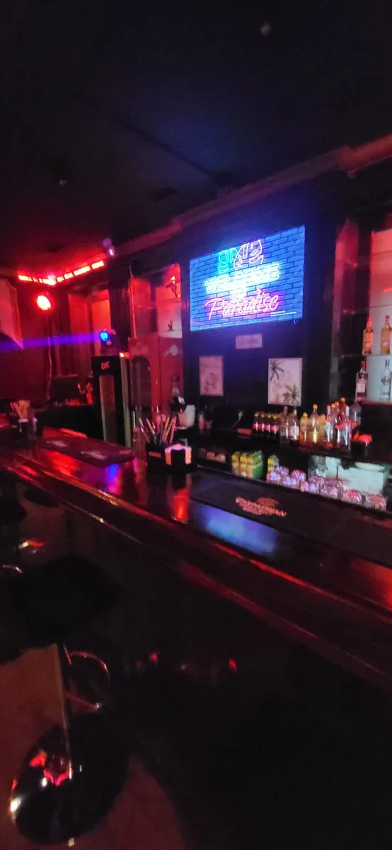 Bar propriu cu reclama neon Welcome to Paradise in spatiul de evenimente