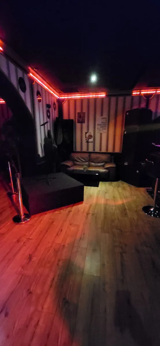 Sala de petreceri cu neon rosu si zona de canapele